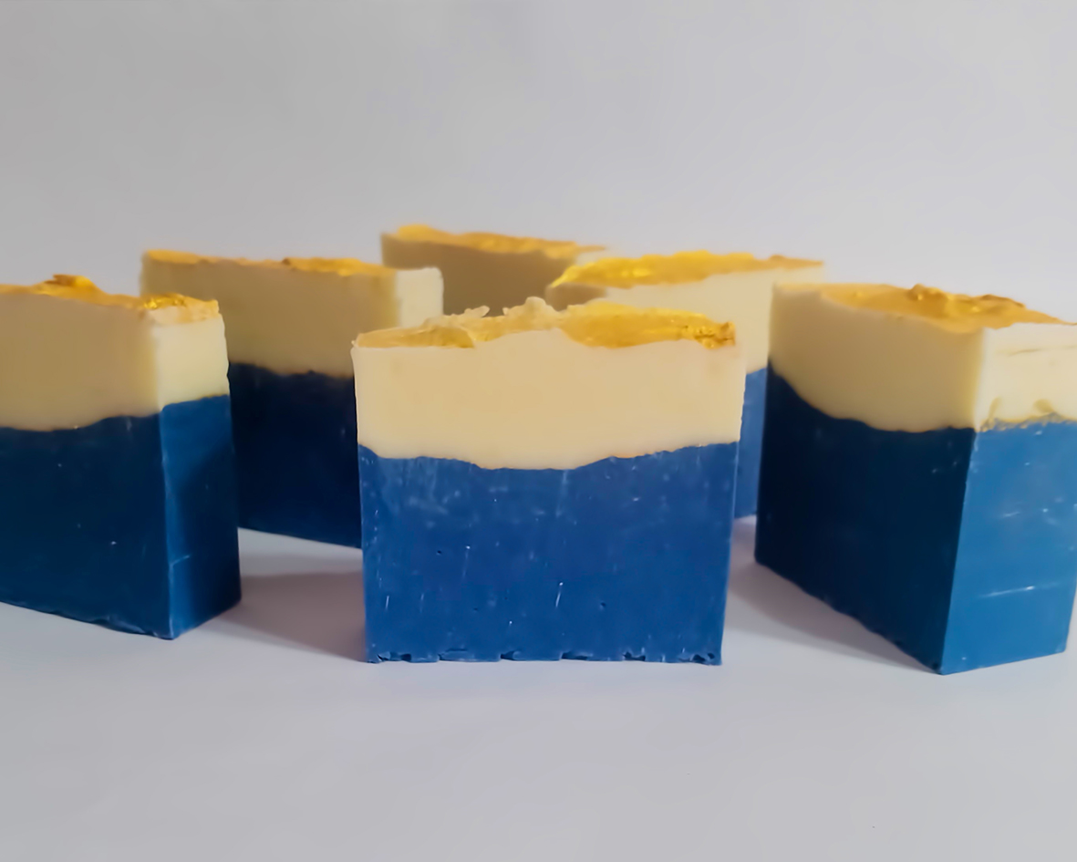 Sapone blu‑giallo con lattato di sodio in piedi su sfondo bianco, visto di fronte.